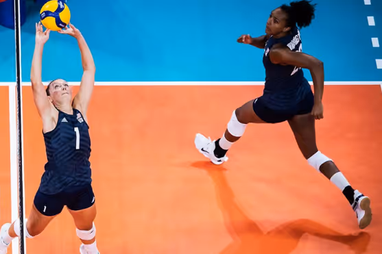 Two women playing volleyball