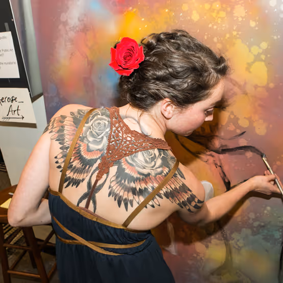 Artist painting on a canvas with her back to the camera