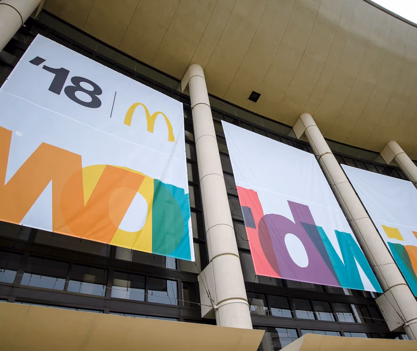 Large banners on a building for McDonald’s Worldwide 2018 convention, featuring the golden arches logo and colorful text.