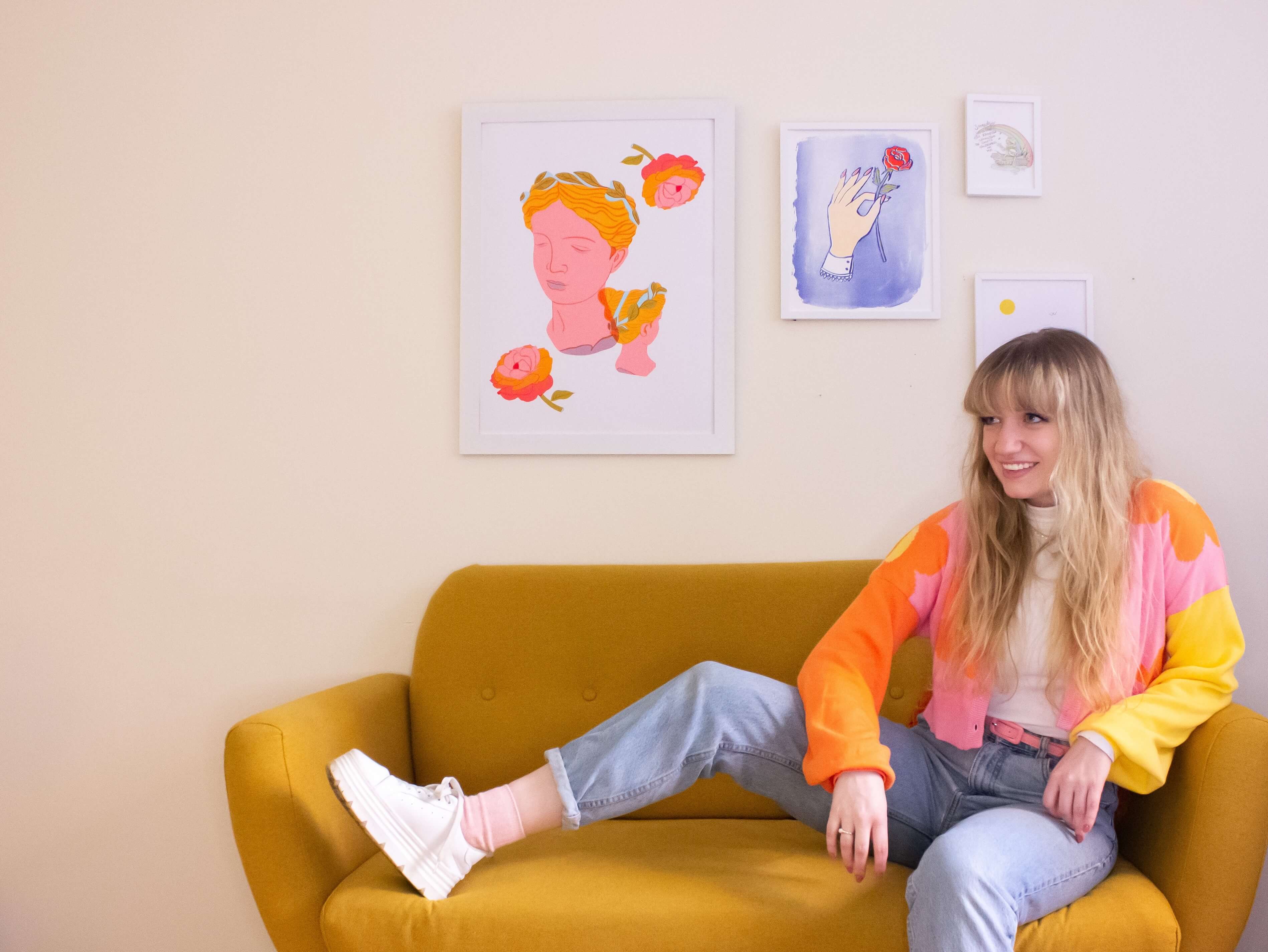 Photo of a woman with blonde hair sitting on a yellow couch. 