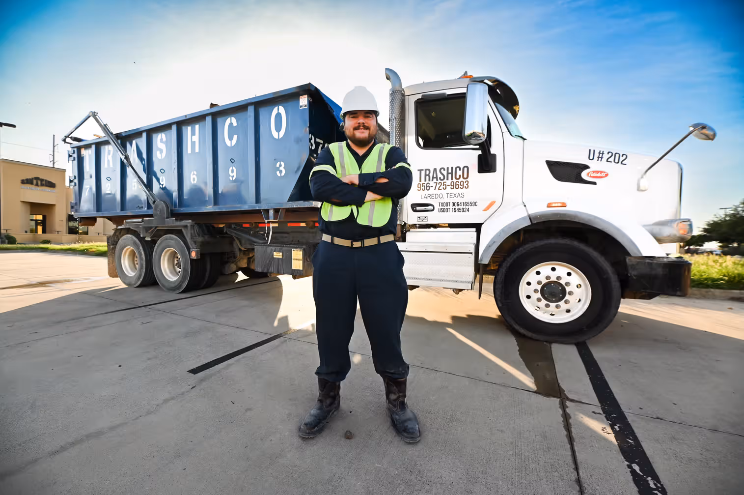 Worker standing in front of a Trashco truck