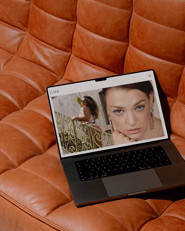 A mockup of a website for Eani Creative on a laptop sitting on a couch.