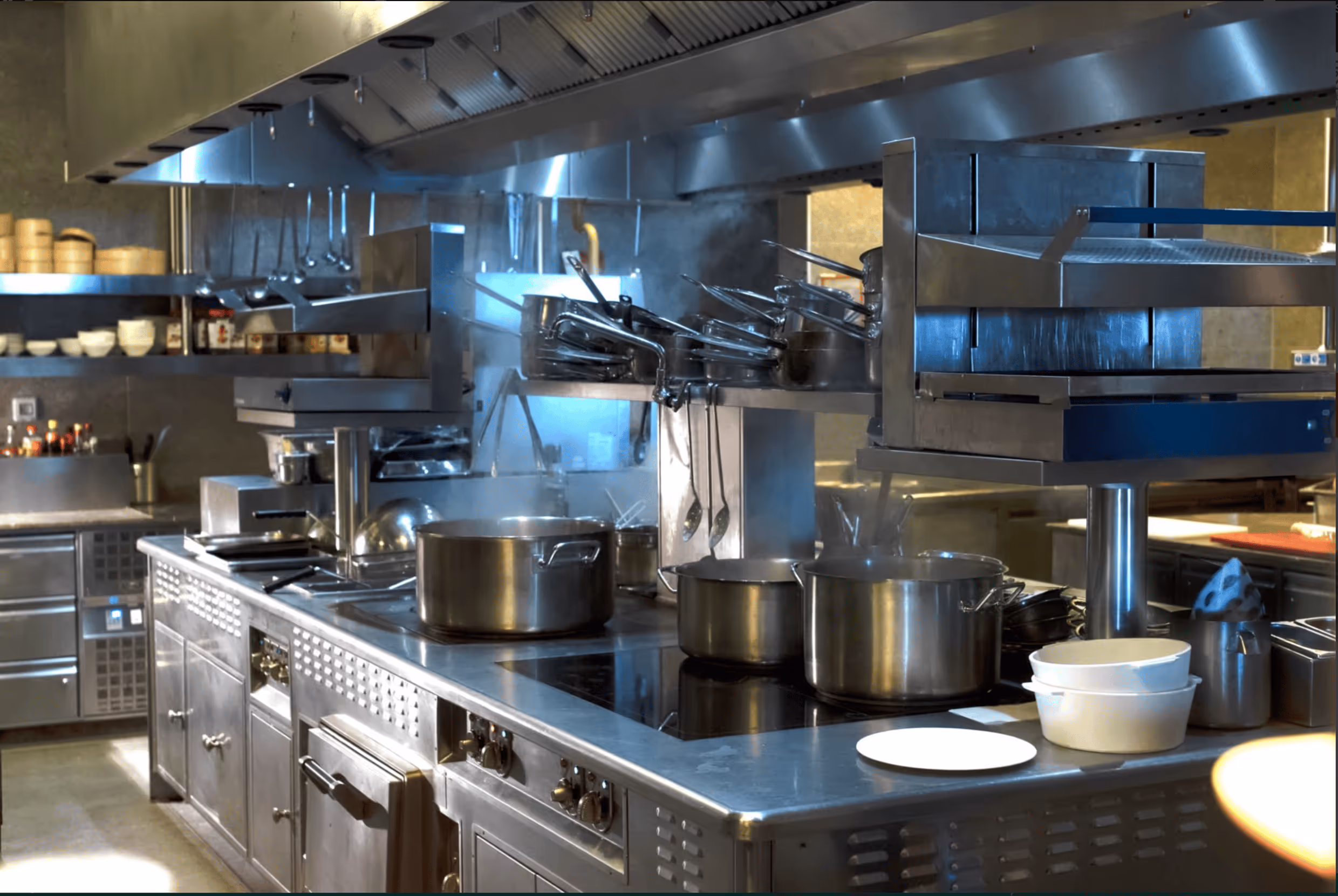 Professional restaurant kitchen with pots and cooking equipment.