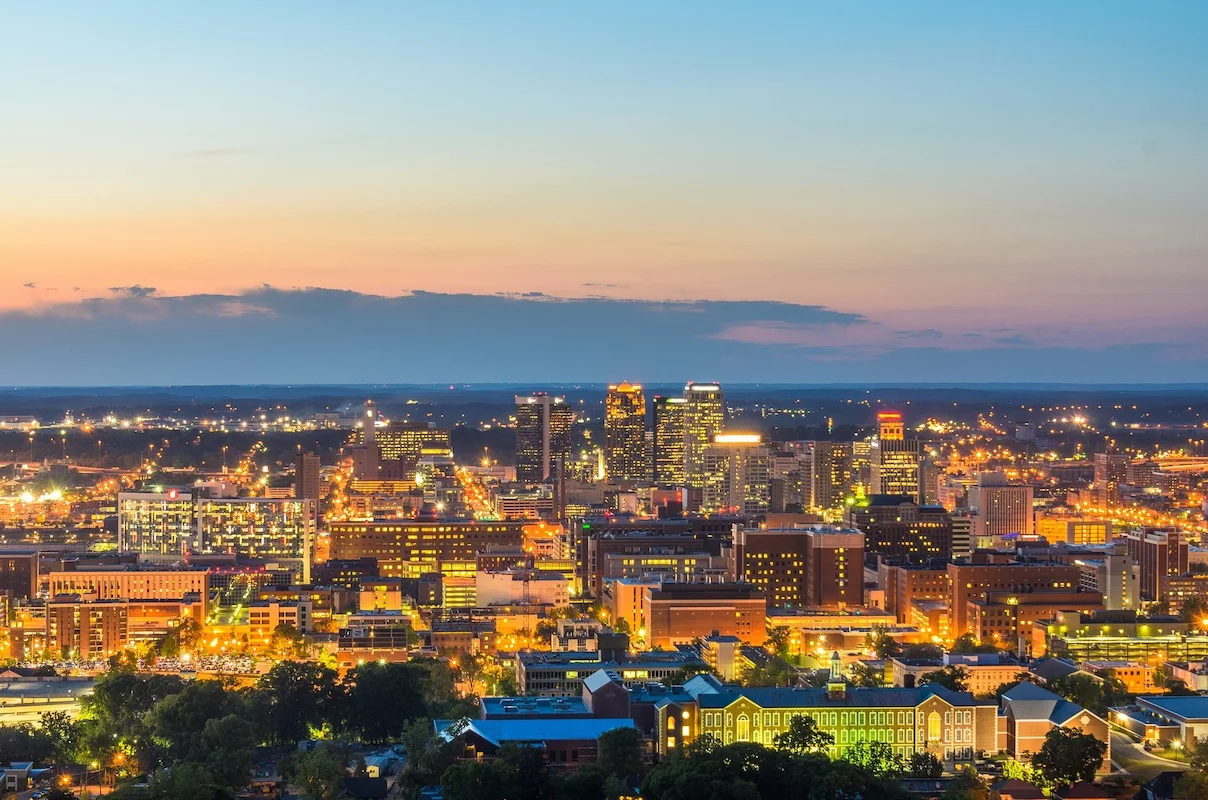 Night skyline photo of a major city in Alabama (e.g., Birmingham), representing a key US market for homeowners looking to sell their house and home investors seeking off market properties