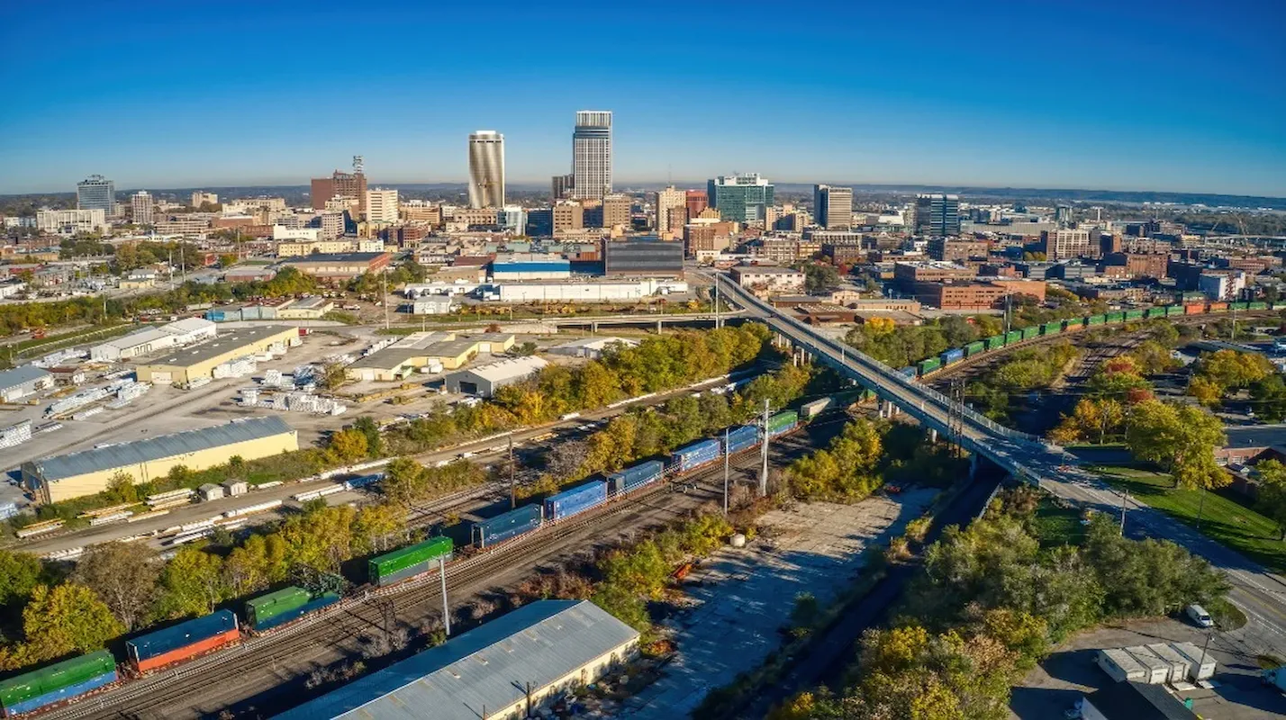 Aerial photo of the Omaha, Nebraska, city skyline with industrial areas and train tracks, representing a key US market for homeowners to sell their house and access home equity