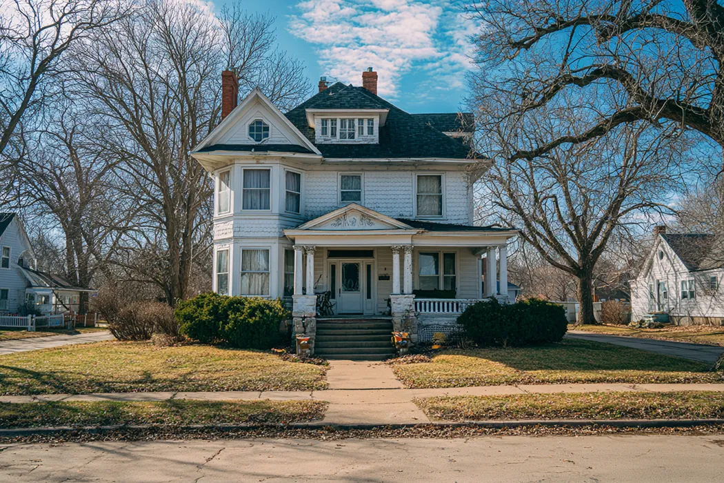 Traditional white farmhouse with a wide front yard in Iowa — sell and stay in your home with Sell2Rent