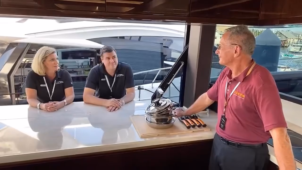 Three people preparing a meal in a Galeon galley around the Kenyon induction cooktop.