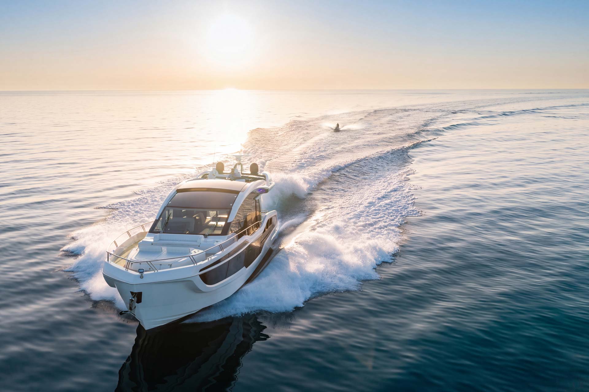 Aerial view of the Galeon 570 SKY running across calm water at dusk.