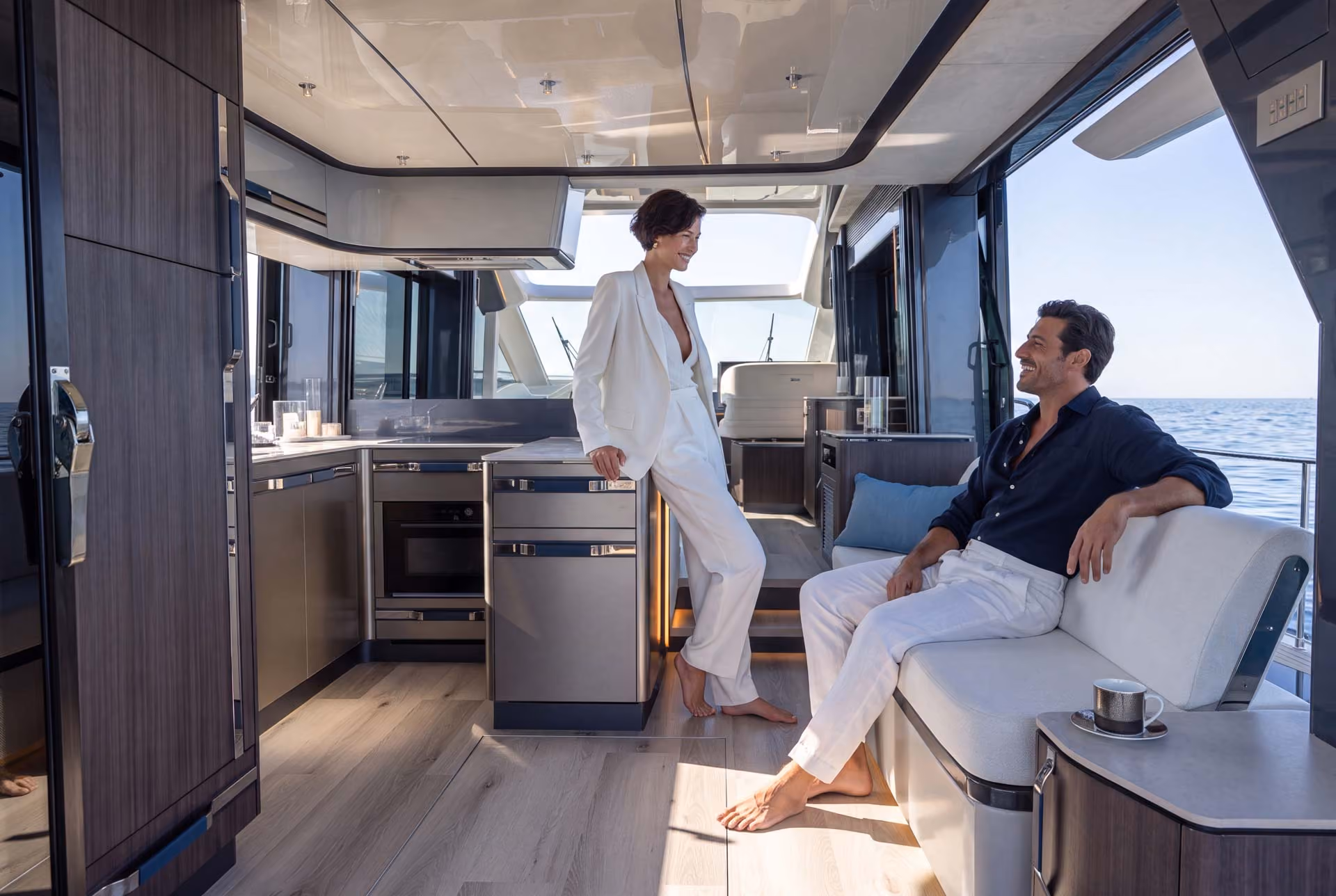 Couple in the Galeon 570 SKY galley, finished in the Atlantic Design Package by Insitu & Partners Studio.