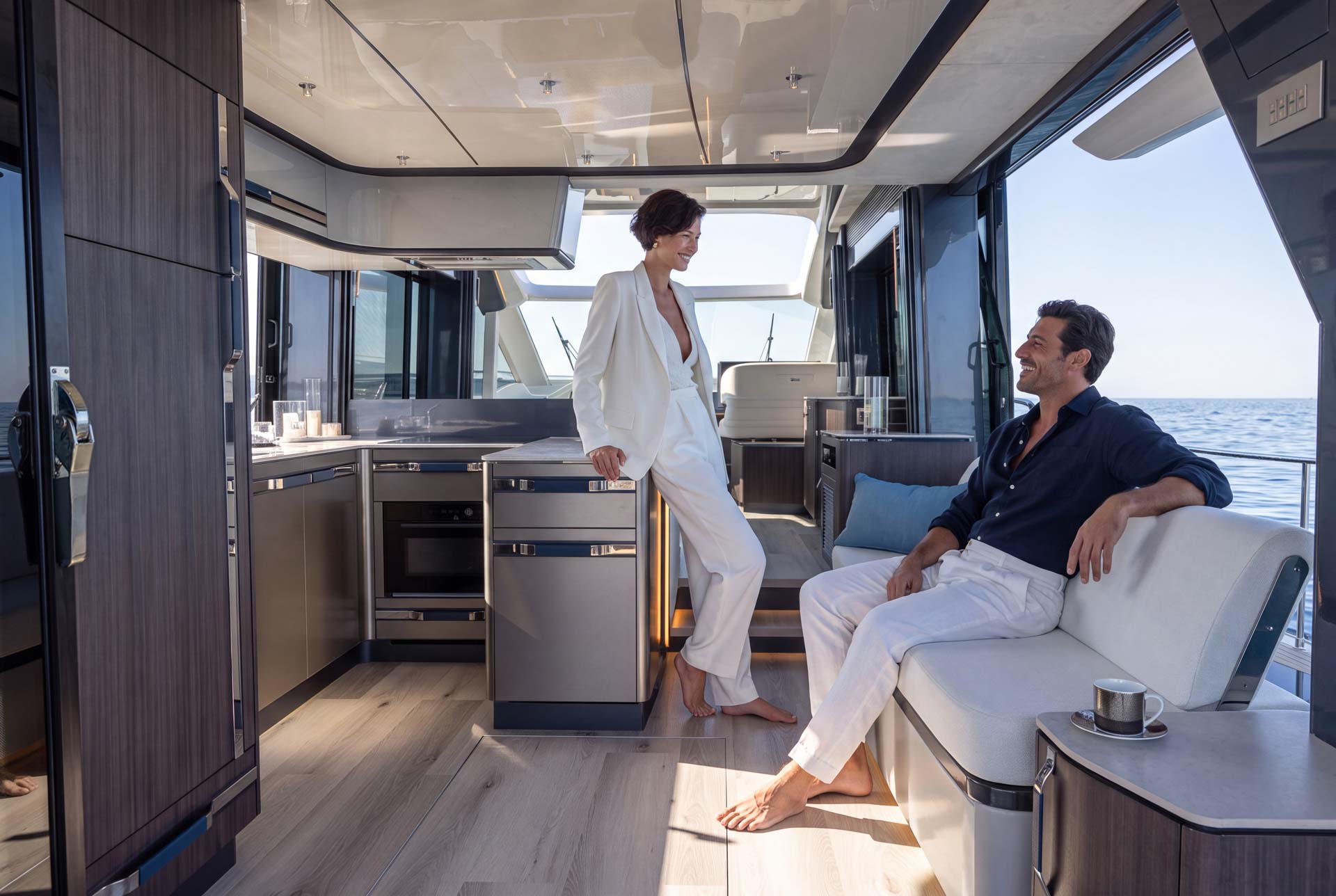 Couple in the Galeon 570 SKY galley, finished in the Atlantic Design Package by Insitu & Partners Studio.