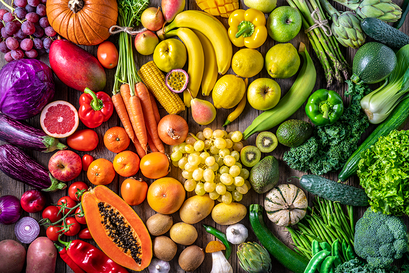 Colorful fruits and vegetables organized in a rainbow spectrum.