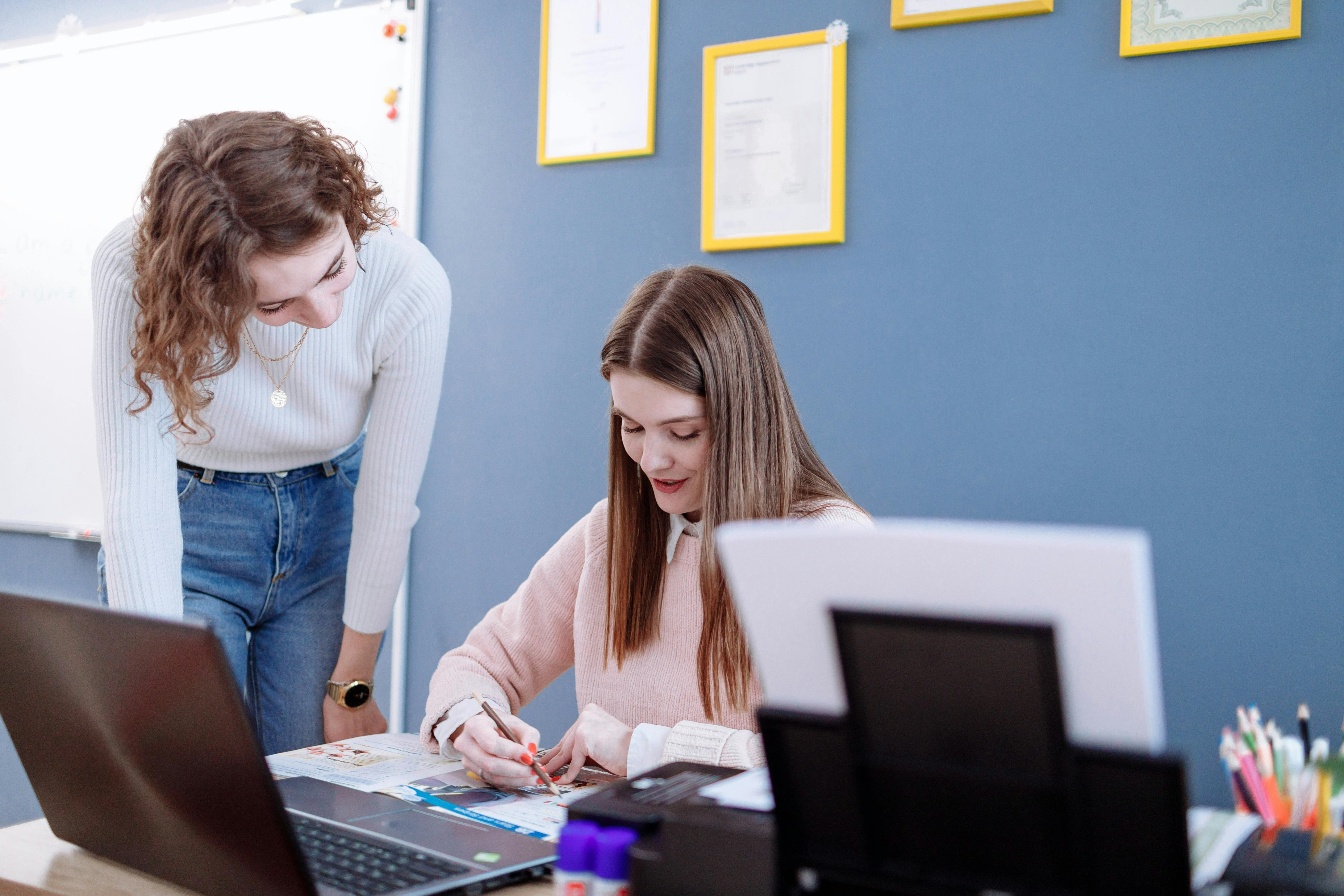 a student studying at a desk with a tutor