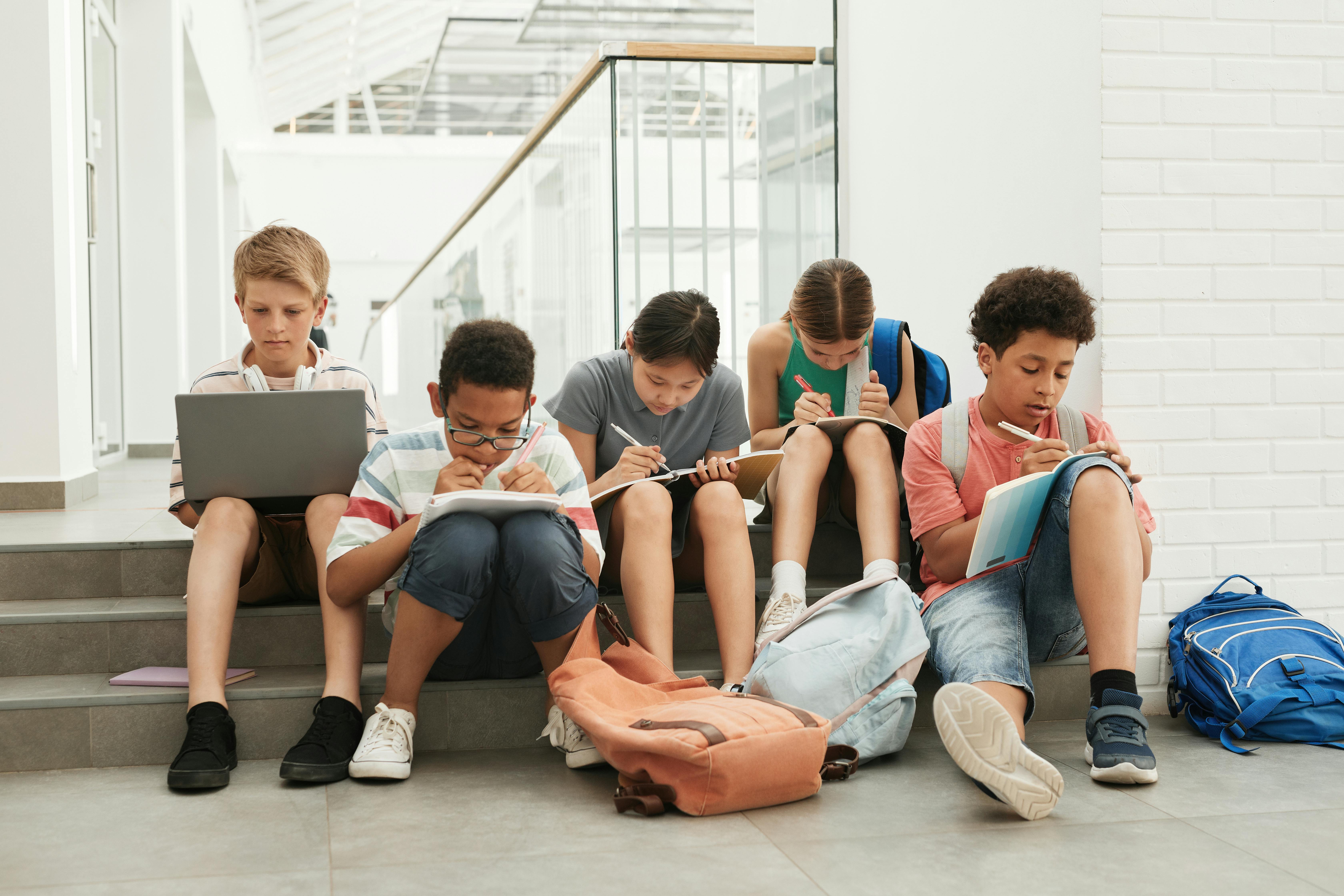students sitting on steps and taking notes