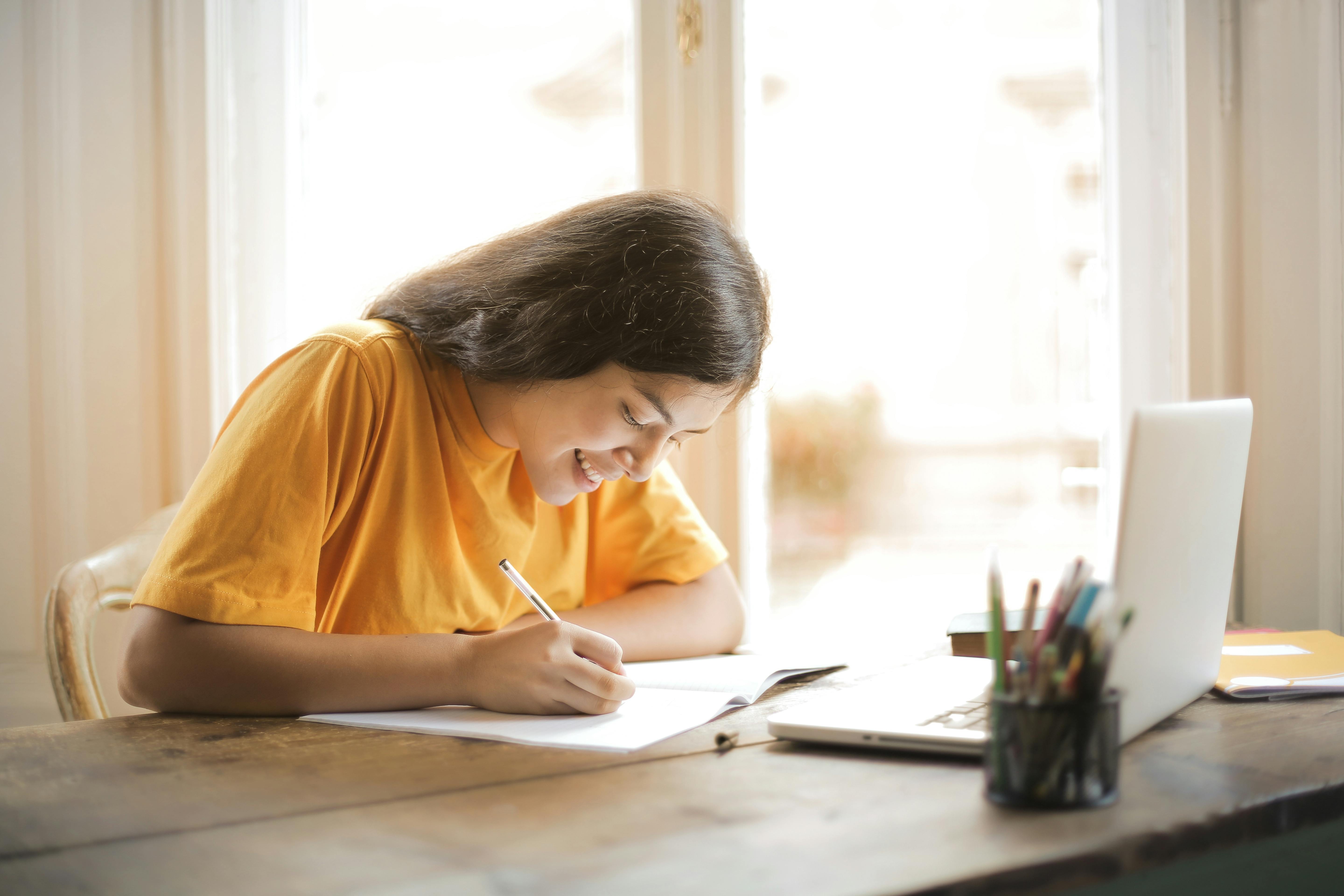 a student taking notes at a desk