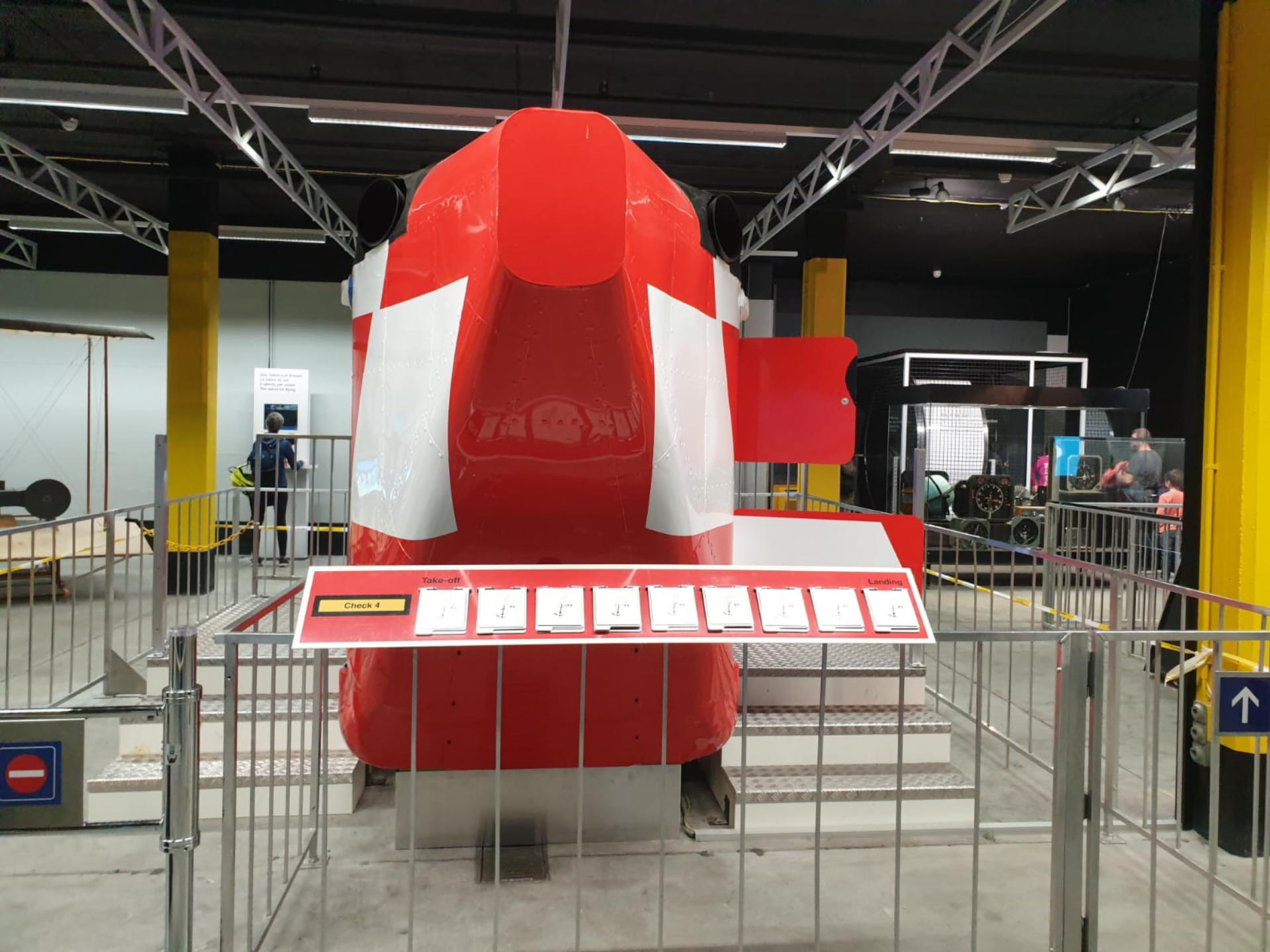 Rotes und weisses Helikoptermodell in Ausstellung mit erklärender Tafel und Absperrung.