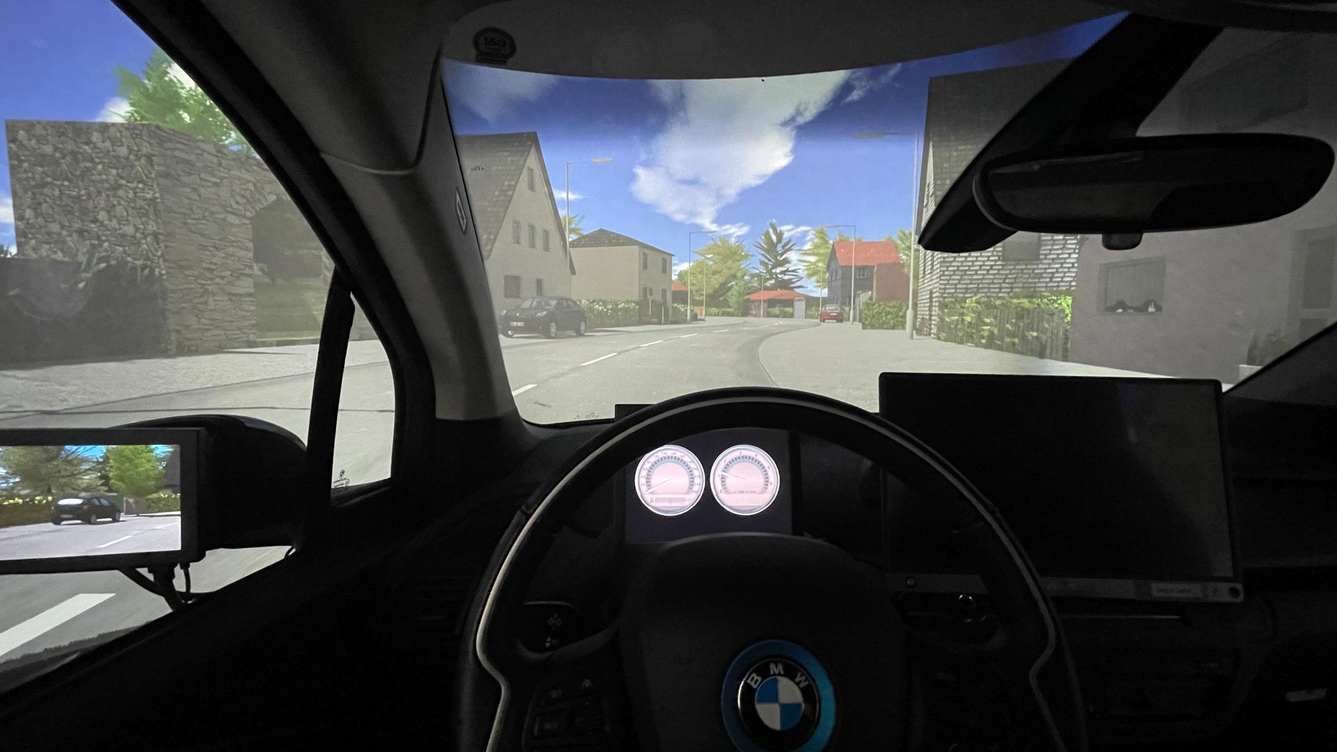 Vue de l'intérieur d'un véhicule BMW sur une rue avec des maisons à la lumière du jour.