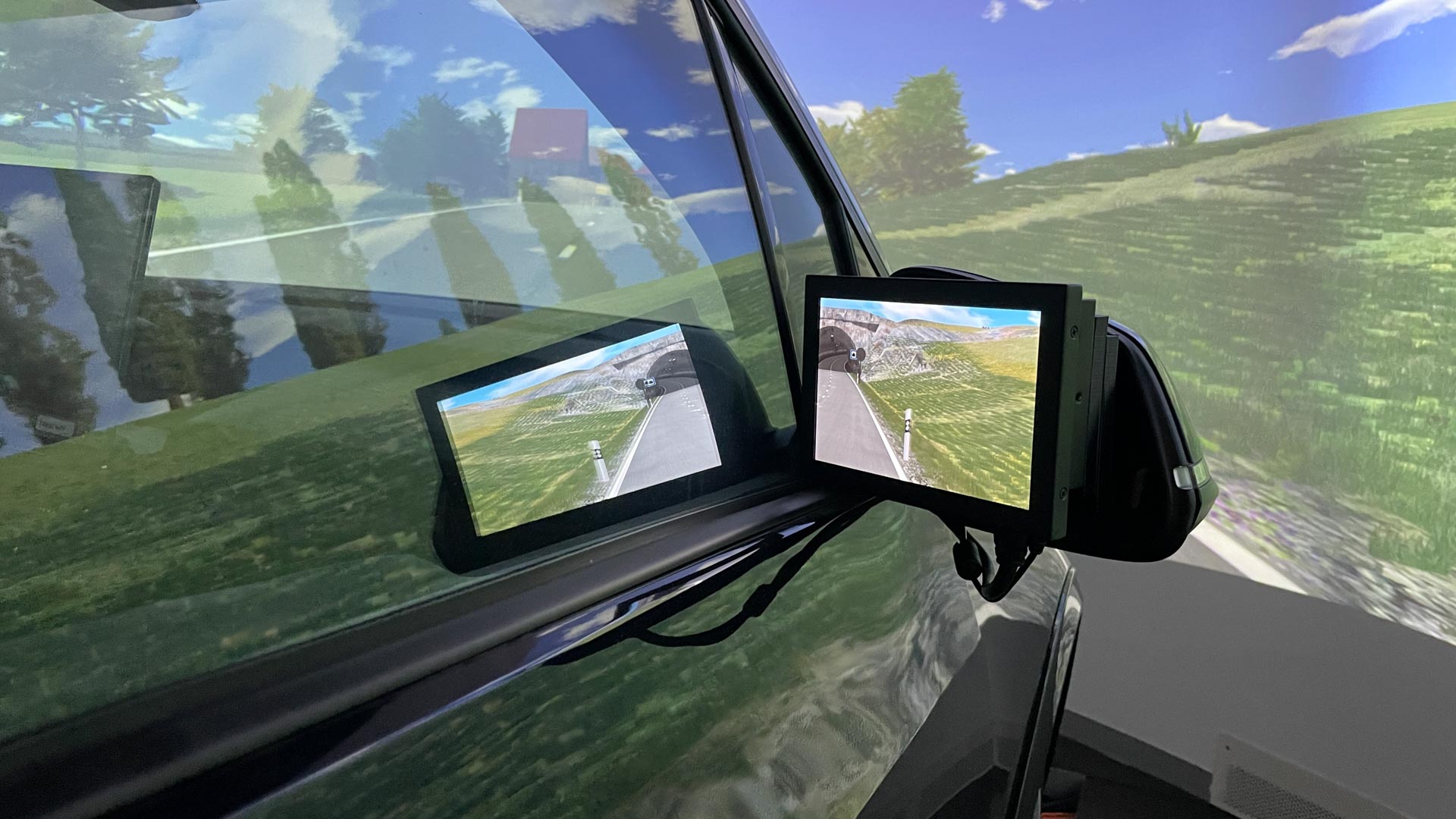 Rétroviseur de voiture avec écran montrant une route dans un paysage simulé.