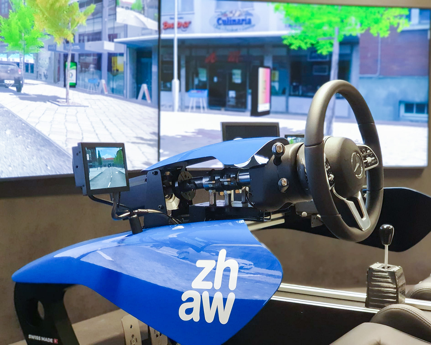 Simulateur de conducteur avec volant, changement de vitesse et vues réalistes de la rue sur les écrans de l'école de conduite.