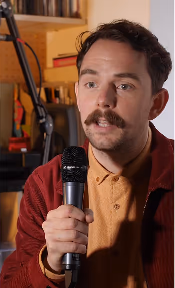 A creator talking in a microphone in their studio.
