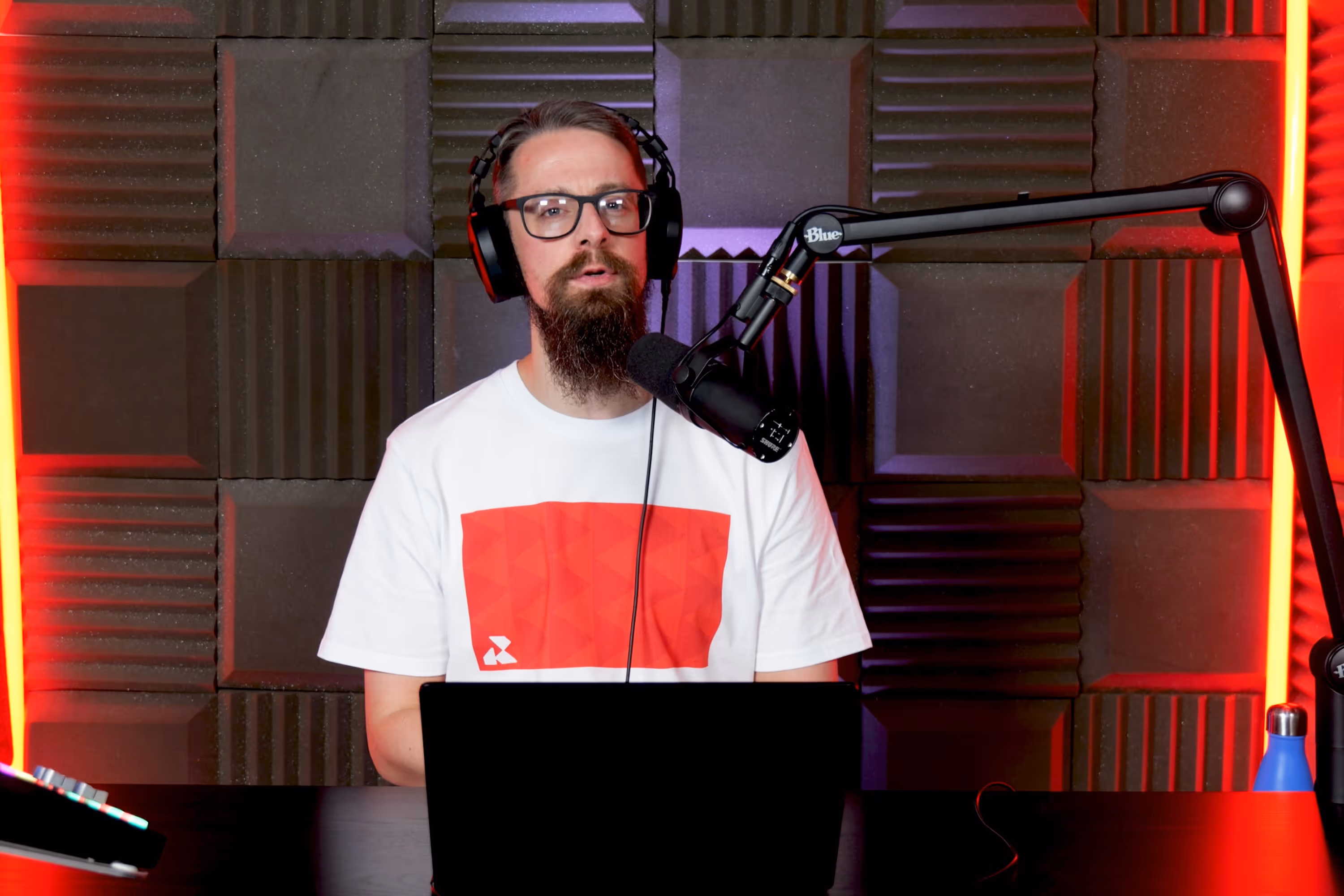 Radio.co team member, Phil Dean, presenting with a microphone on a boom arm and a laptop.