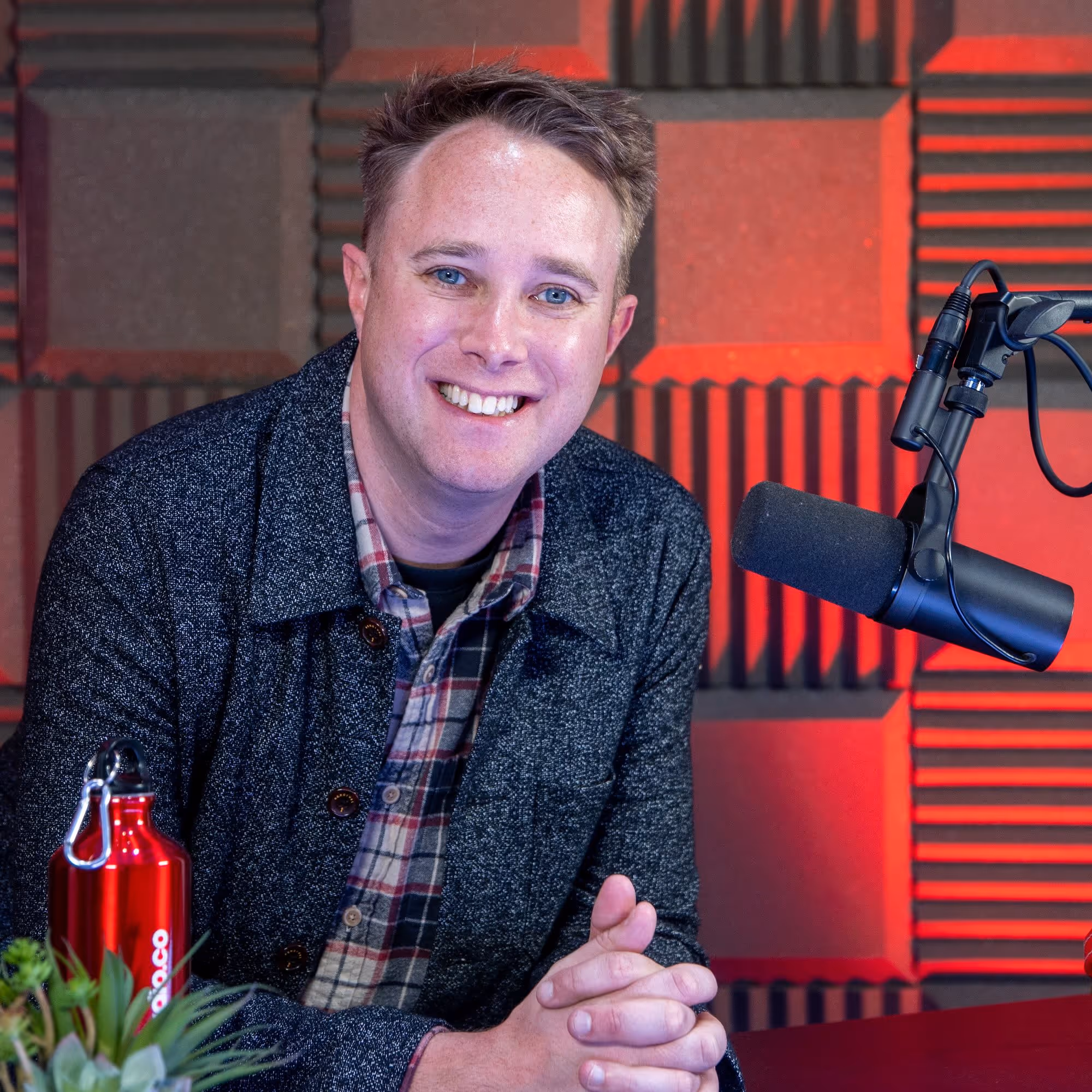 Radio.co founder James Mulvany posing for a photo with a microphone.