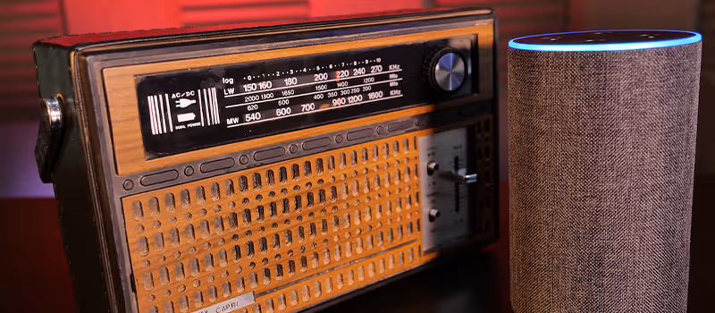 An old school radio alongside a smart speaker.