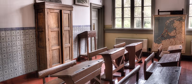 An empty, rather old, classroom for students.