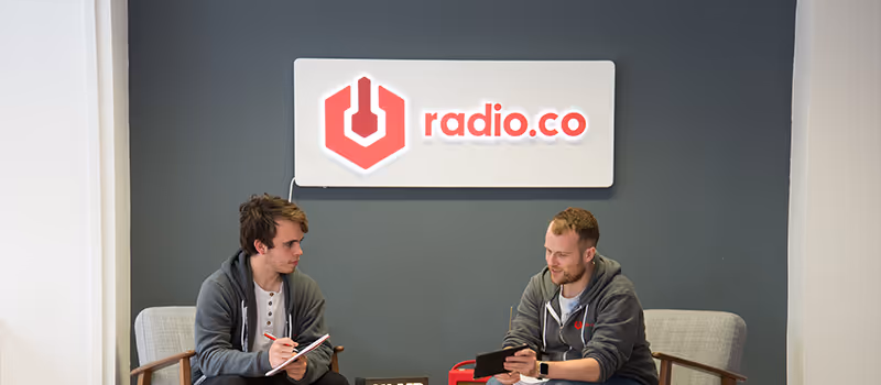 The team at Radio.co discussing in the office.