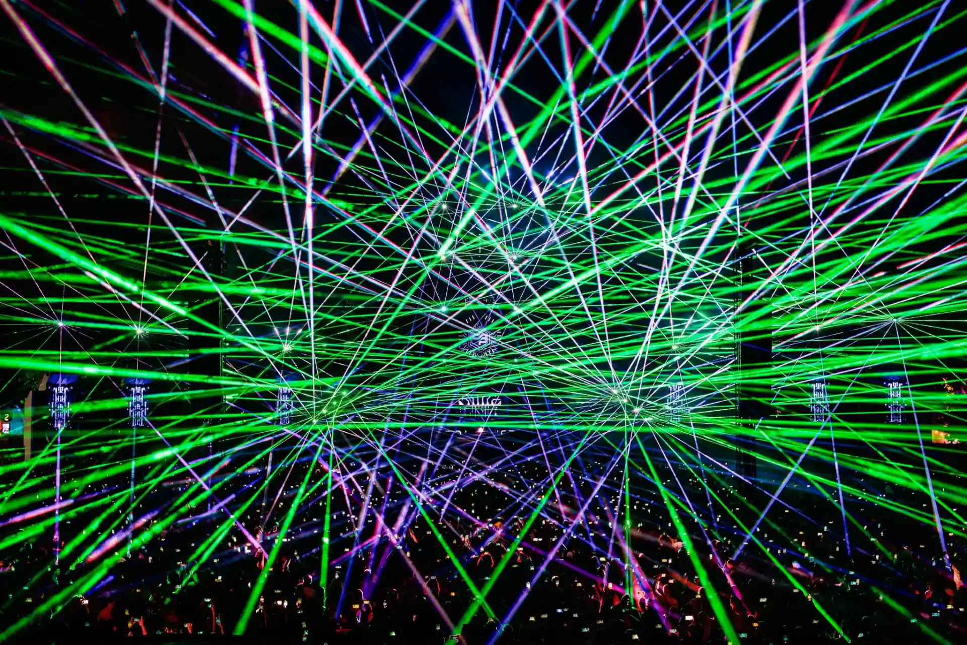 Decibel Outdoor laser show with vibrant green and blue light beams
