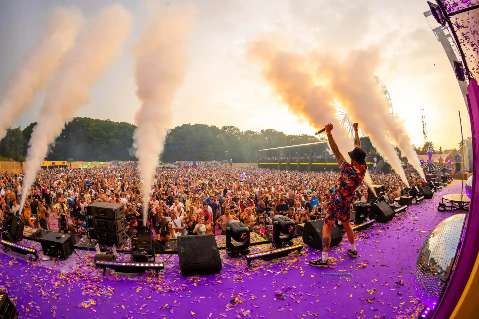 Decibel Outdoor festival with massive crowd, smoke effects, and performer on purple stage