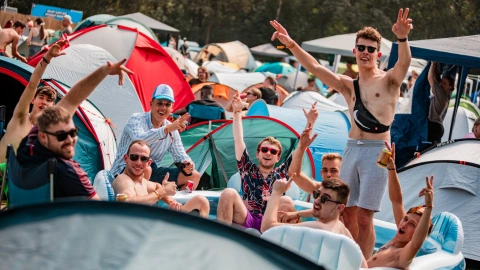 A group of people at lakeside campsite, friends field