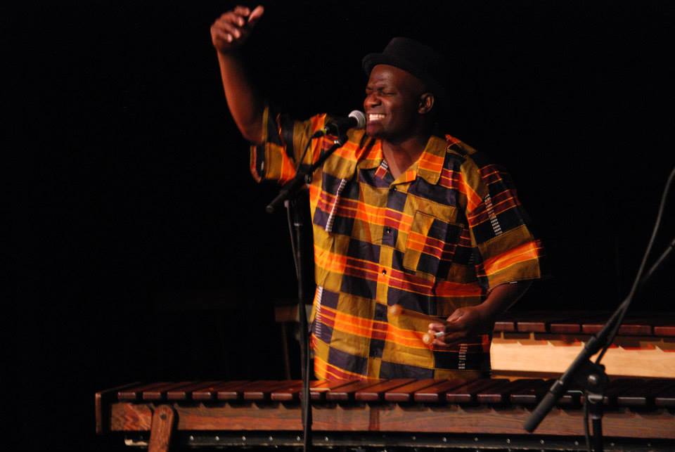 Tendai Muparutsa sings and plays marimba on stage.