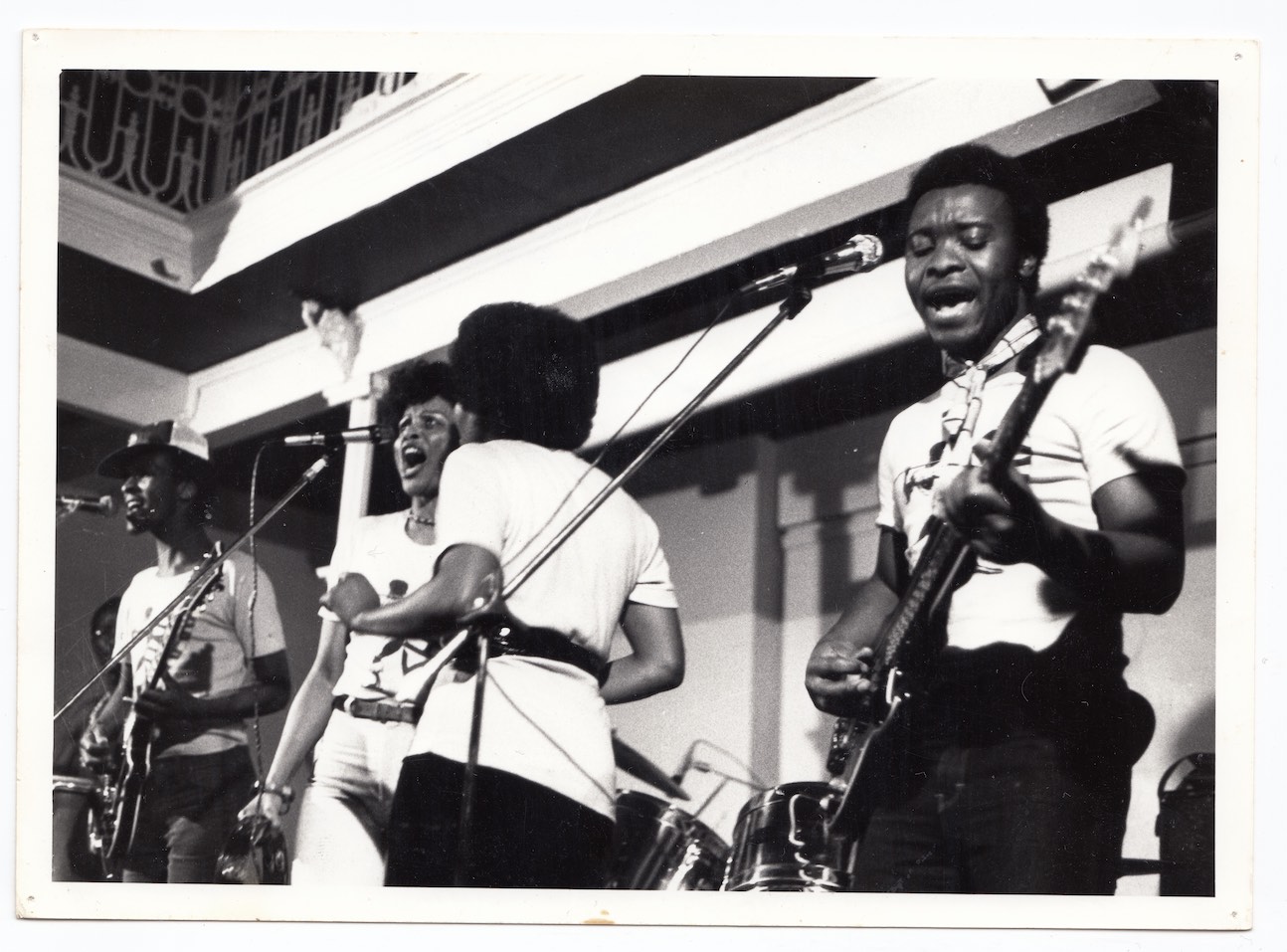 Four singers perform on stage.