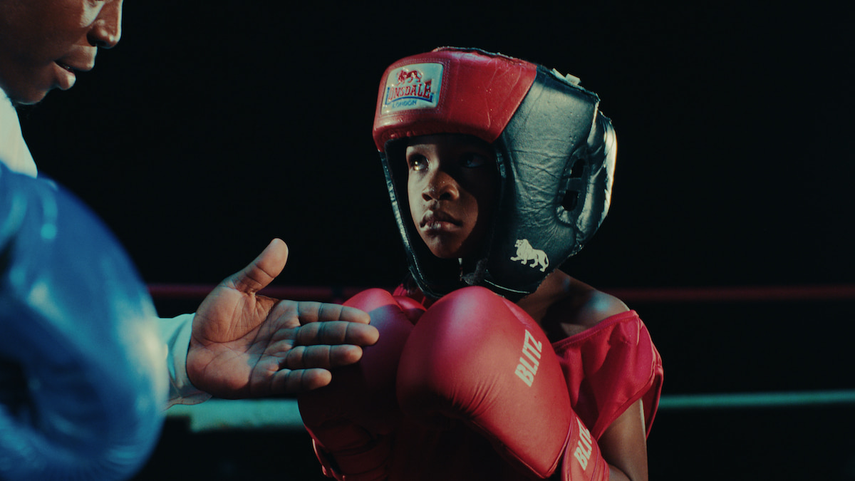 A young boy in boxing gear.