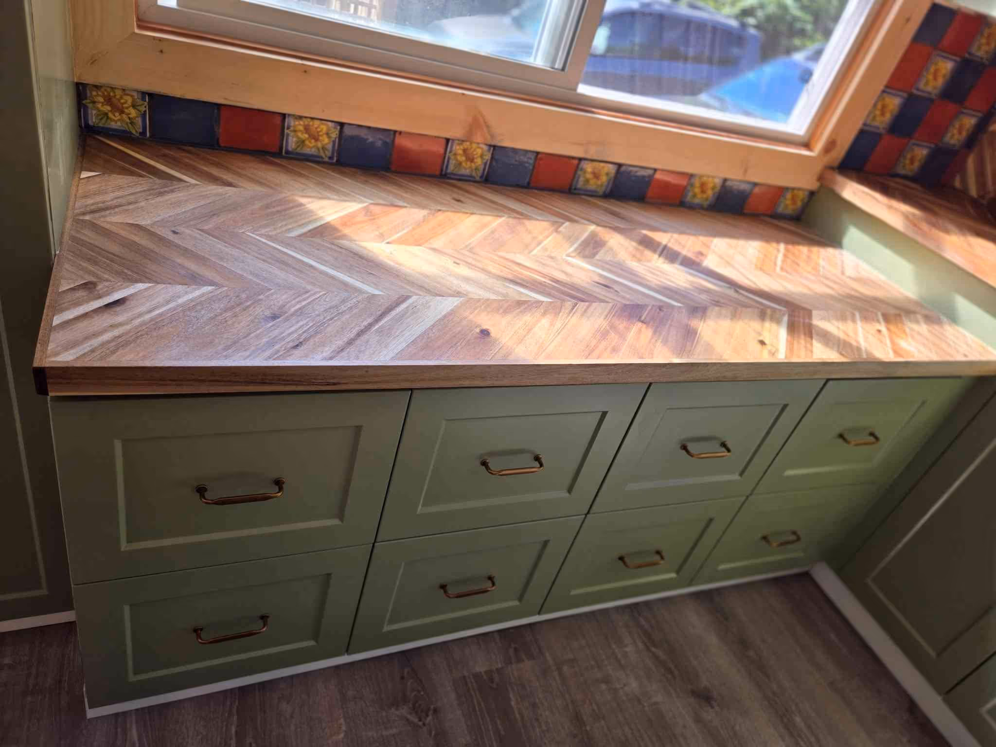 ✔️Cabinet re-facing with sage colored shaker doors and drawer fronts. Painted former white gable ends to match
✔️Acacia Chevron Butcher Block Countertop, oiled with food grade finish 
✔️ Tongue and groove knotty pine v-groove 1x6 ceiling throughout kitchen, dining, and hallway 
✔️Sterling Oak 7mm  Click Lock Waterproof Luxury Vinyl Plank Flooring throughout kitchen, dining, hallway and mud room.  
✔️Tiled backsplash 
✔️ Natural wood window finishes with insulation and vapour barrier ensured first 
✔️ Douglas fir stained baseboards #
✔️ Remodeled buffet also with butcher block featuring custom vinyl record dividers.  Deleted ceiling valance 
✔️Fresh paint in kitchen &  dining rooms
✔️Restored kitchen island with matching countertop, addition of shaker doors, fir base and sage paint.
✔️ Updated light fixtures and a couple of switch and plug replacements
✔️ Stainless steel appliances install, (hood fan, dishwasher and fridge 