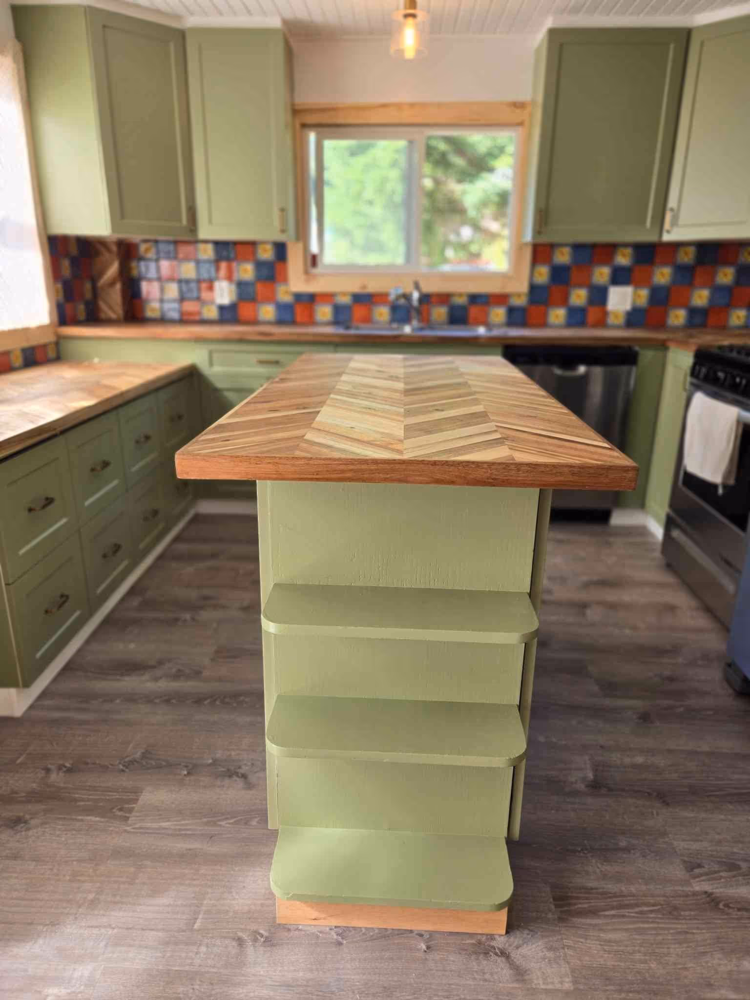 ✔️Cabinet re-facing with sage colored shaker doors and drawer fronts. Painted former white gable ends to match
✔️Acacia Chevron Butcher Block Countertop, oiled with food grade finish 
✔️ Tongue and groove knotty pine v-groove 1x6 ceiling throughout kitchen, dining, and hallway 
✔️Sterling Oak 7mm  Click Lock Waterproof Luxury Vinyl Plank Flooring throughout kitchen, dining, hallway and mud room.  
✔️Tiled backsplash 
✔️ Natural wood window finishes with insulation and vapour barrier ensured first 
✔️ Douglas fir stained baseboards #
✔️ Remodeled buffet also with butcher block featuring custom vinyl record dividers.  Deleted ceiling valance 
✔️Fresh paint in kitchen &  dining rooms
✔️Restored kitchen island with matching countertop, addition of shaker doors, fir base and sage paint.
✔️ Updated light fixtures and a couple of switch and plug replacements
✔️ Stainless steel appliances install, (hood fan, dishwasher and fridge 