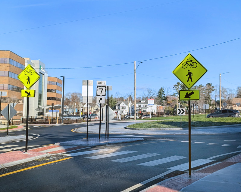 Street view of a roundabout on Route 7 in Pittsfield with pedestrian and bicycle crossing infrastructure.