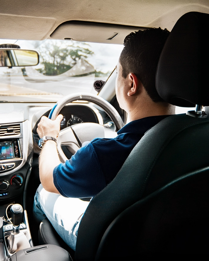 Five uniformed men standing in front of a car, a white van, and a motorcycle in a parking lot during daytime.