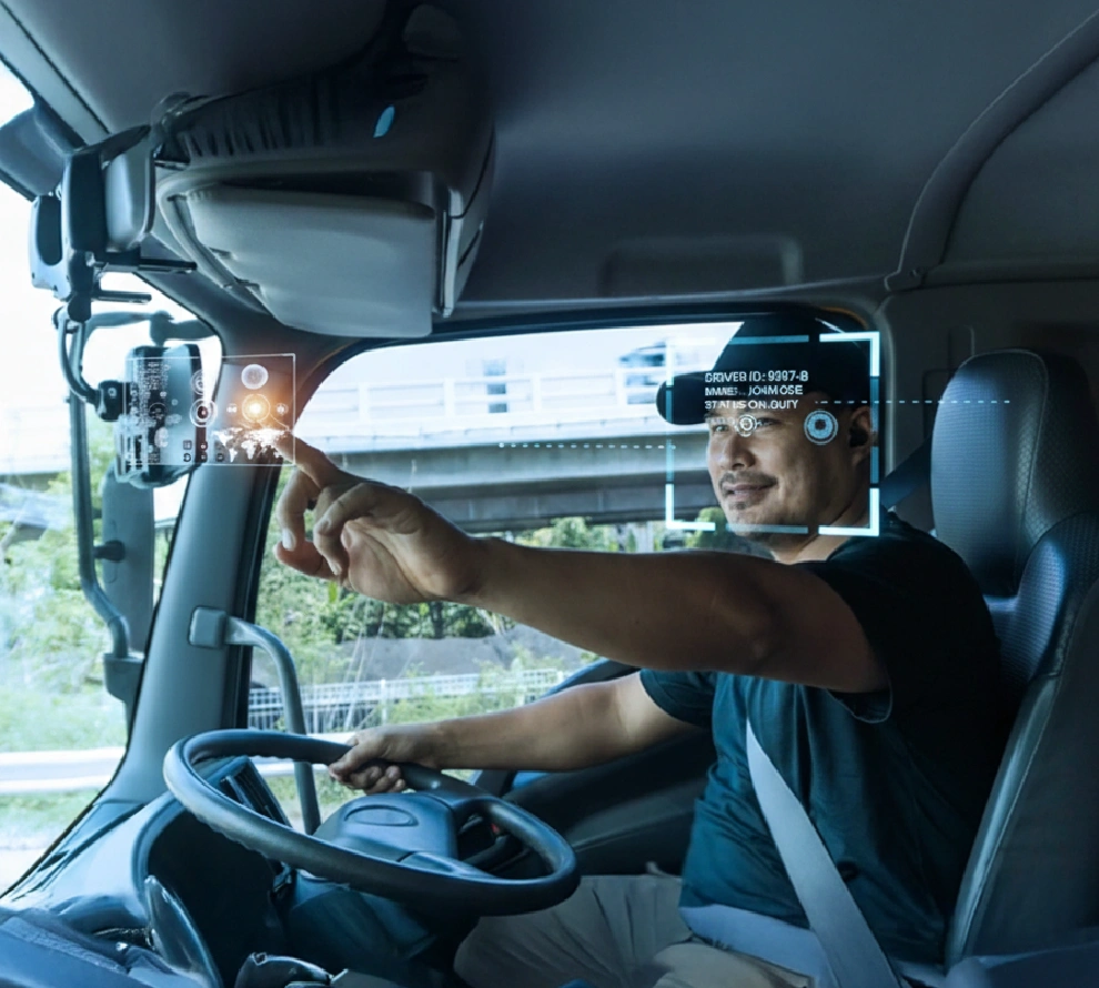 Man driving a vehicle while interacting with a transparent digital interface projected inside the windshield.