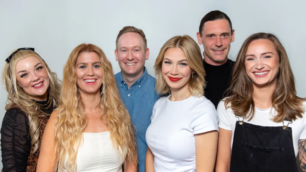 Professional team of expert hair stylists at B. Young Salon Wichita posing together on a white background