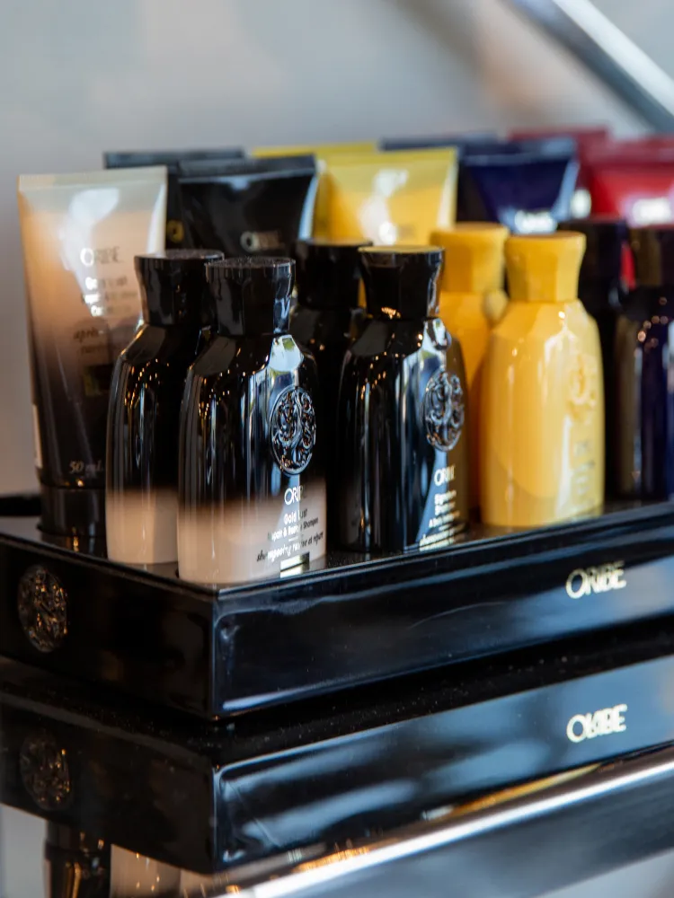 Closeup of B. Young Salon Oribe hair products displayed beautifully on a shelf in their modern Old Town Wichita salon.