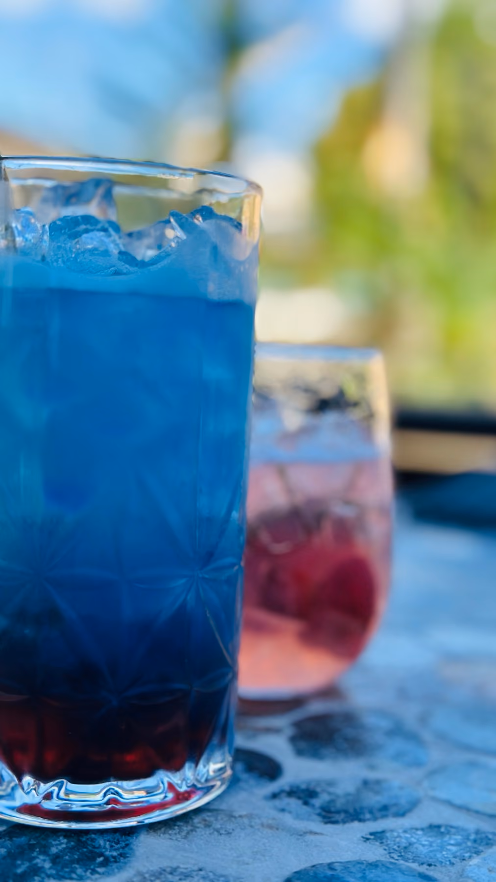 Two colorful Garden Bar cocktails served over ice.