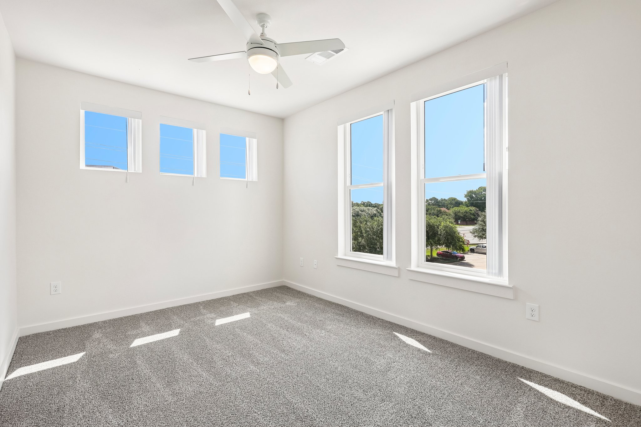 carpeted bedroom with multiple windows