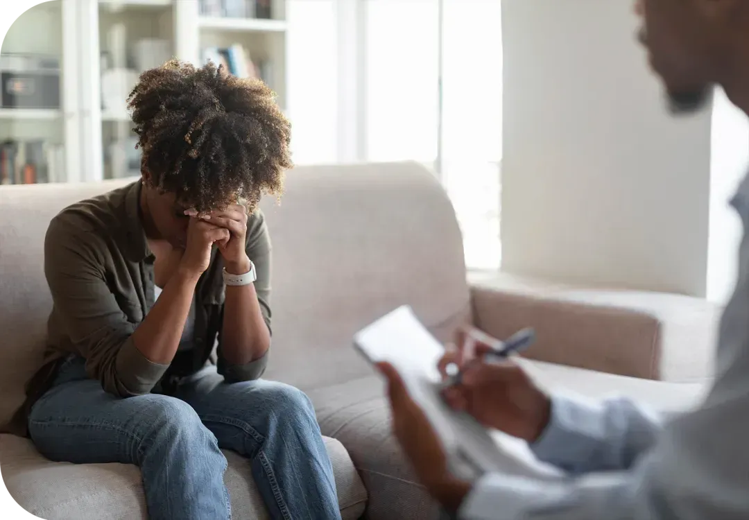 a person sitting on a couch with a notepad in their hand