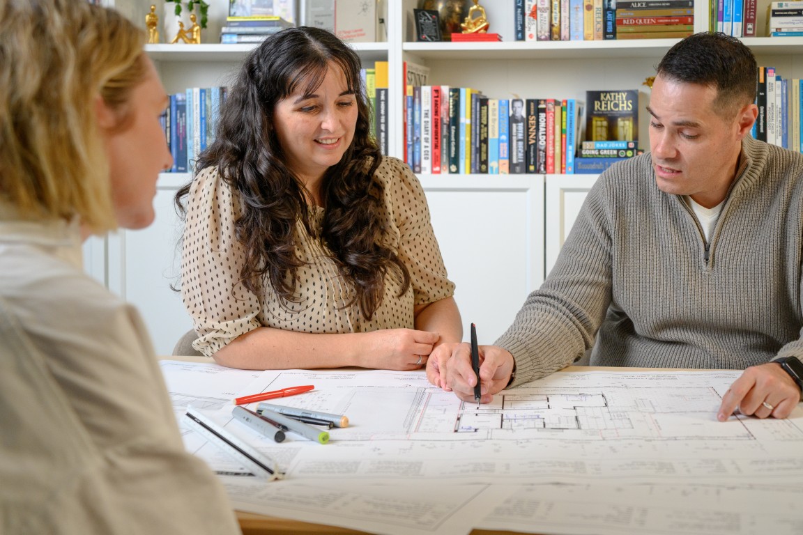 Quorum Studios architect consultation Brisbane meeting with clients reviewing bespoke home design plans and architectural drawings for custom residential project