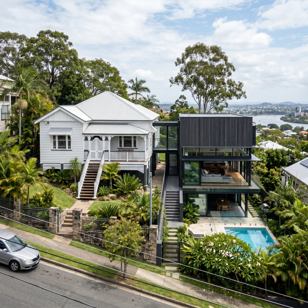 Contemporary home beside a heritage Queenslander on Hamilton Brisbane hillside — concrete and glass in a heritage overlay area, renovation architect Brisbane