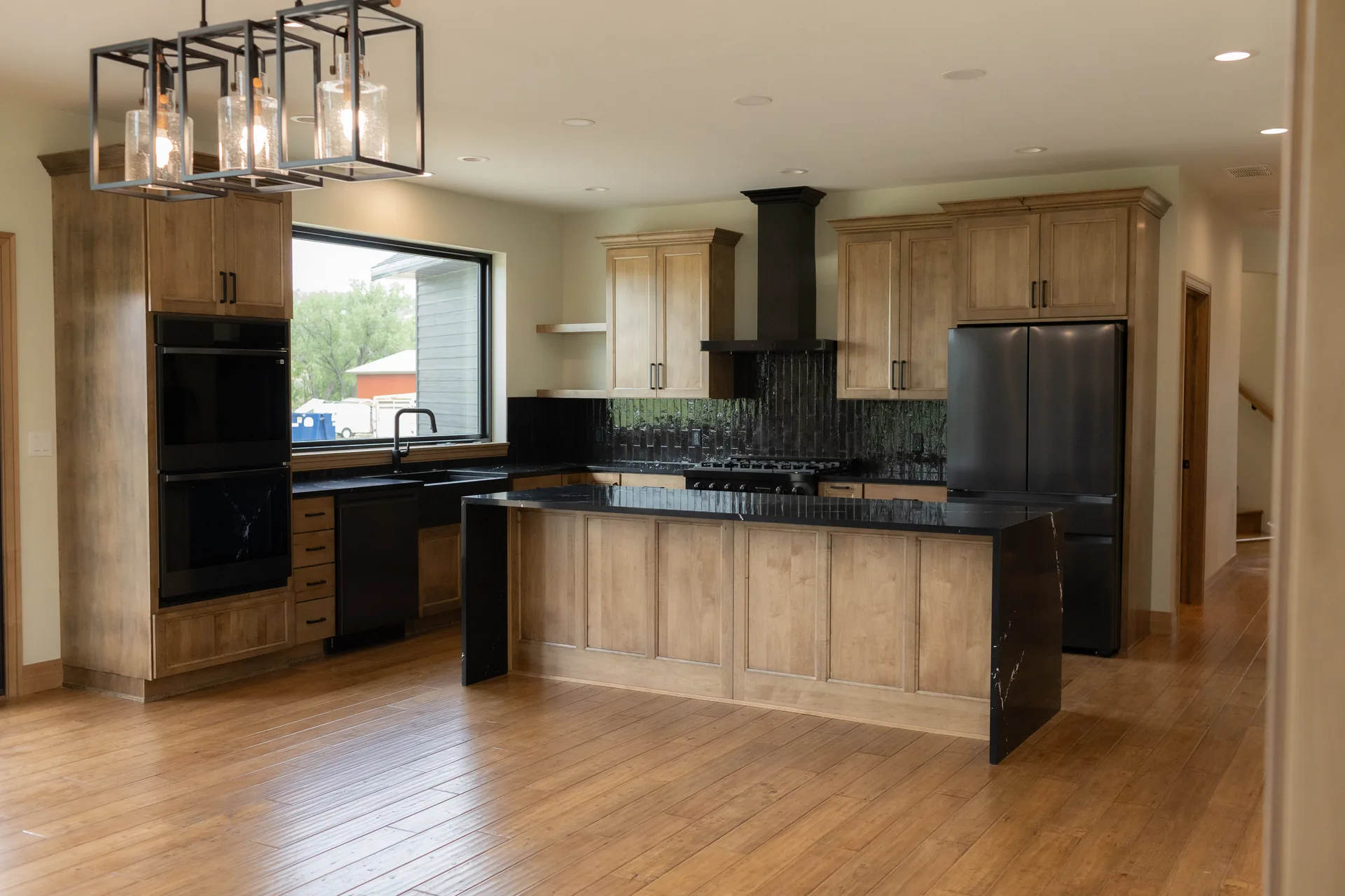Open-concept kitchen with waterfall-edge island and pendant lighting
