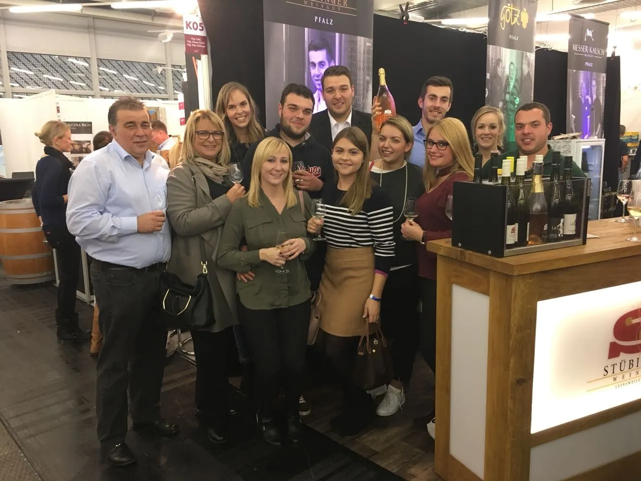 Inmitten einer fröhlichen Gruppe auf einer Weinmesse zeigt sich Sabine Jechow als nahbare, sozial vernetzte Persönlichkeit – ein wertvoller Aspekt für systemisches Coaching und Erfolgstrainings mit menschlicher Tiefe.
