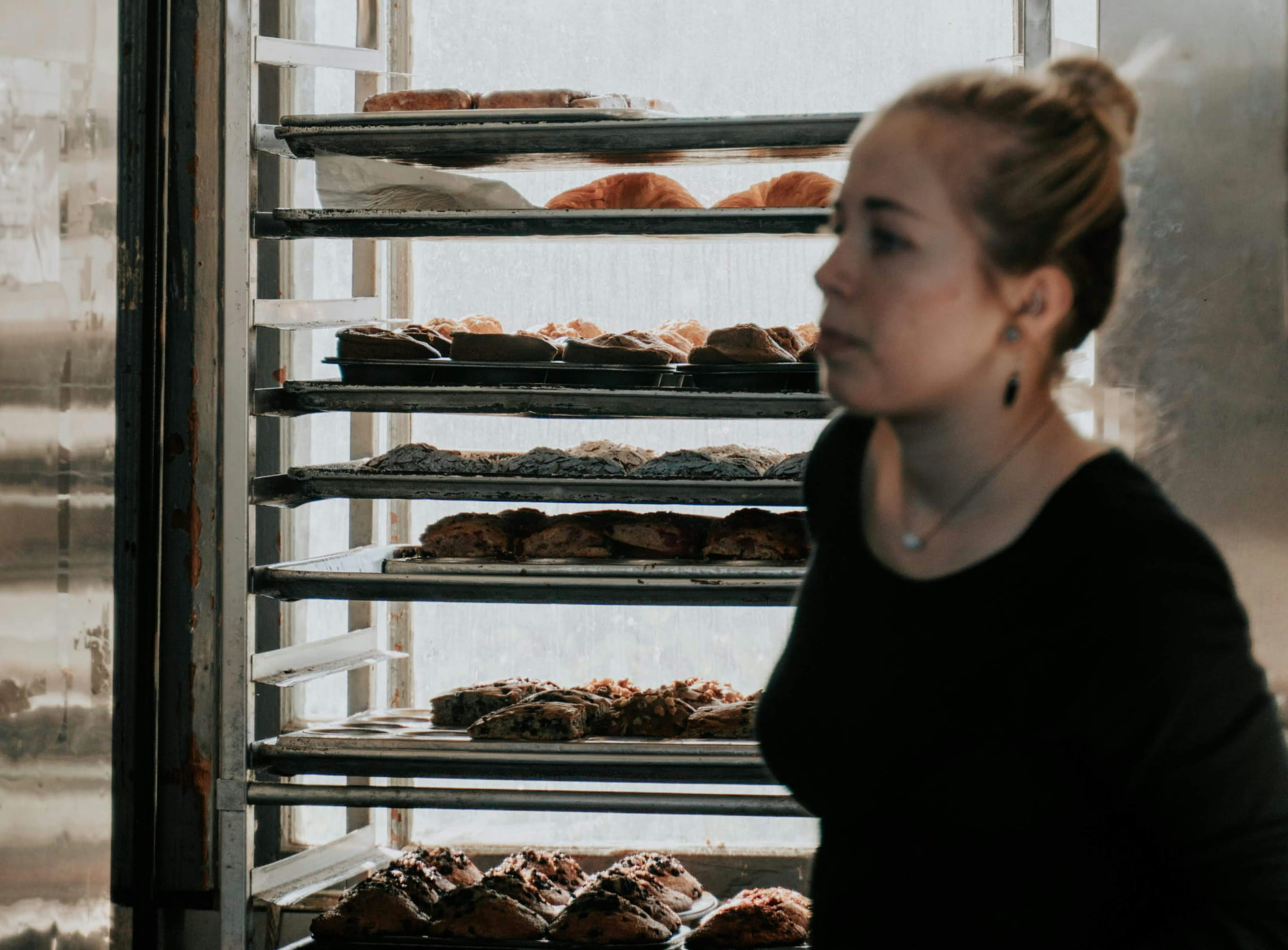 Eine Frau die in einem Backbetrieb arbeitet.