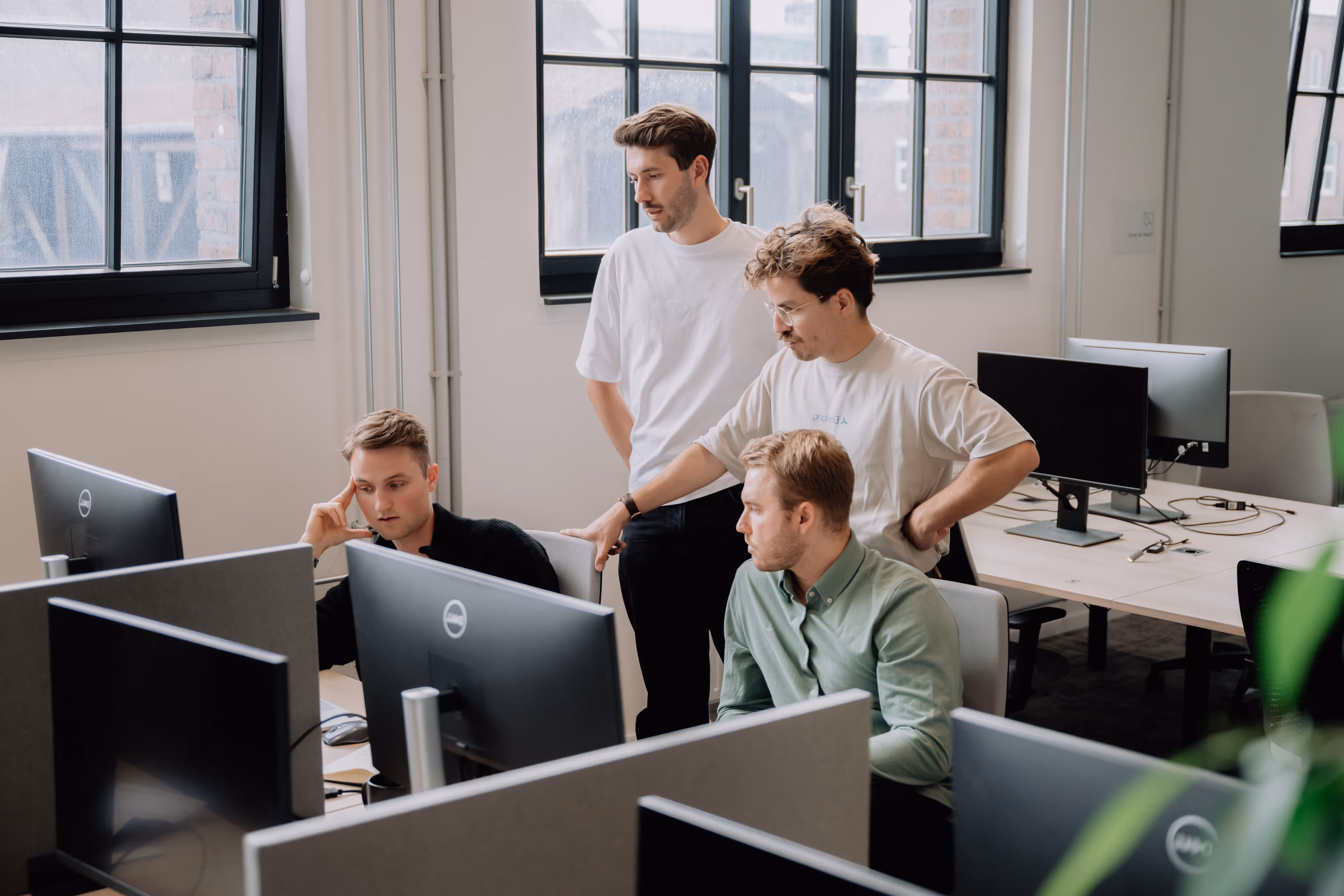 Die Gründer von Einklang gemeinsam im Büro vor einem Computerbildschirm.